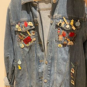 Selling denim jacked with pins and patches .